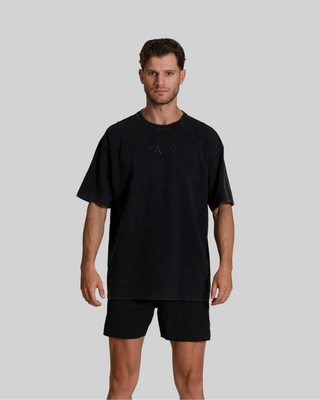 Man wearing a black t-shirt and shorts on a gray background